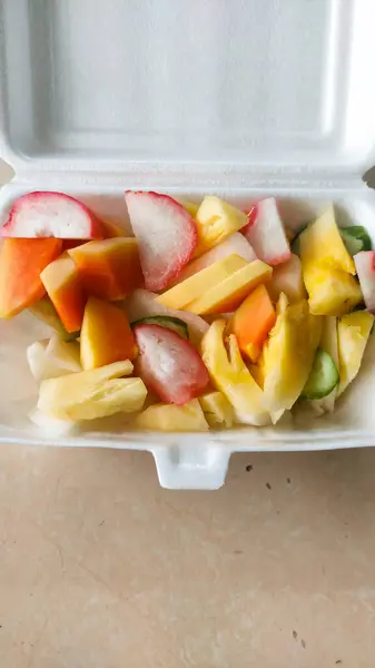 Rujak, tatlı ve baharatlı taze meyve karışımıdır. Tabakta servis edilir.