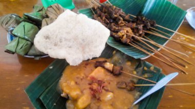 Kraker ve muz yapraklarına sarılmış Padang satay.