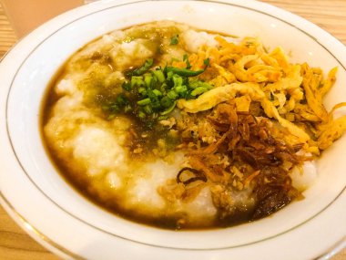 Soslu tavuk lapası, kızarmış soğan ve kereviz serpiştirilmiş.