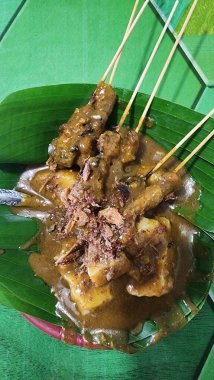 Muz yapraklarında servis edilen Padang satay lezzetli..