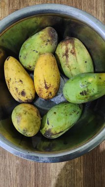 Taze sarı mango ağaçları, dayanıklılık ve sağlığı korumak için bol miktarda C vitamini içerir. Beyaz bir tabakta servis edilir..