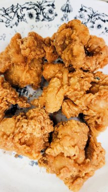 Beyaz bir tabakta kızarmış tavuk, yakın plan, üst manzara.