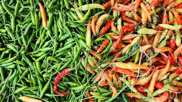 Yeşil, kırmızı ve sarı kırmızı kırmızı biberler bir markette sergileniyor.