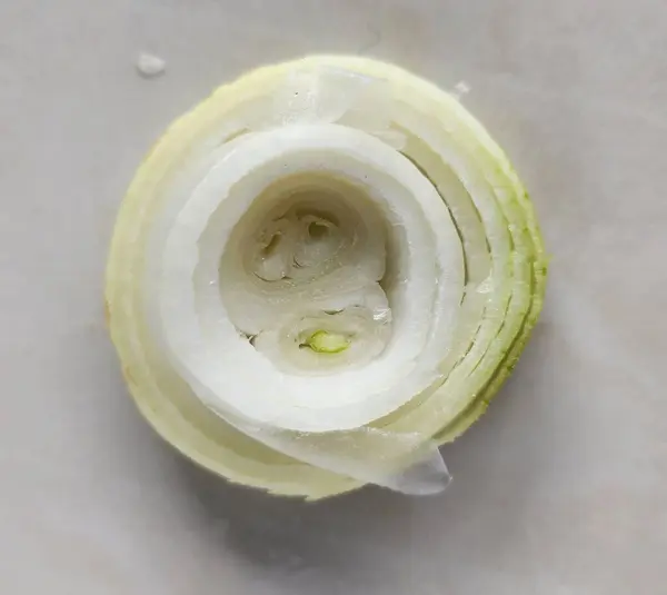 Beyaz arka planda dilimlenmiş soğan. Seçici odak.