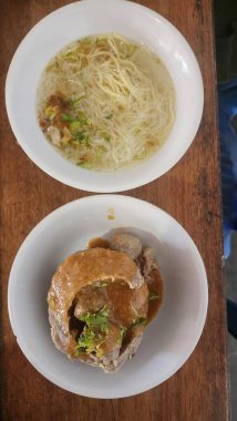 İçinde kocaman köfteler ve ayrı et suyu bulunan iki kase.