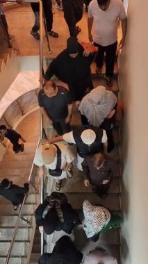 Caminin merdivenlerinde insanlar var.