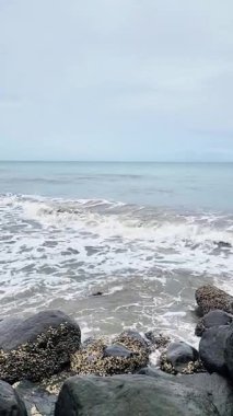 Padang City, Batı Sumatra, Endonezya 'nın batı kıyısındaki sahil dalgaları büyük doğal kayalardan oluşan dalgalara çarpıyor. Deniz kıyısının güzel manzarası. 