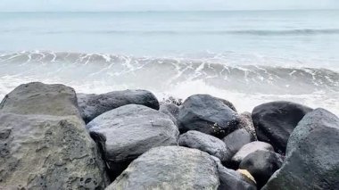 Padang City, Batı Sumatra, Endonezya 'nın batı kıyısındaki sahil dalgaları büyük doğal kayalardan oluşan dalgalara çarpıyor. Deniz kıyısının güzel manzarası. 
