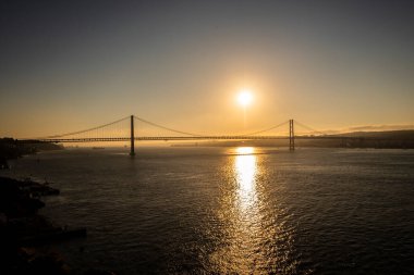 Lisboa, Portekiz. 25 de Abril Köprüsü ve Tajo Nehri 'nde gün batımı.