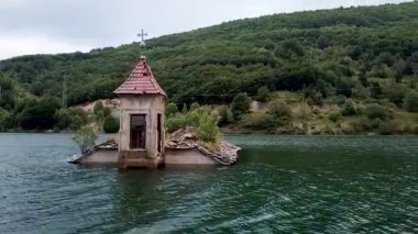 Bizans döneminden kalma eski Hıristiyan Ortodoks kilisesi bir gölün ortasında batmış ve yok olmuş. Güzel drone hava görüntüsü.