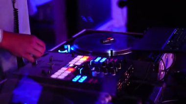 Bir DJ mikserinden ve DJ 'den bir parti için karışık müzik. Güzel renkli renkler ve ışıklar.