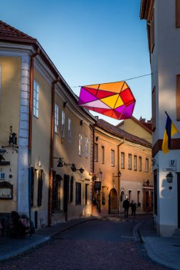 Vilnius, Litvanya - 26 Eylül 2022: İkinci Dünya Savaşı sırasında Yahudi gettosunun bir parçası olan tarihi bir cadde. Evlerin arasında renkli bir çokyüzlü fener.. 