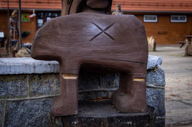 Sobotka, Poland - December 31, 2022: Wooden copy of a famous ancient sculpture of the Slezan Bear. Entrance of the tourist house and restaurant Pod Wiezyca. 