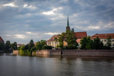 Wroclaw, Polonya - 29 Haziran 2021: Odra Nehri 'nden Ostrow Tumski' deki katedral kilisesine bir manzara. Tarihi ortaçağ mimarisi. Altın saat, gün batımı.. 