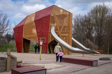 Wroclaw, Polonya - 31 Mart 2023: Mamut Community Park 'taki çocuk parkındaki büyük tahta bir mamutta oynayan çocuklar. 