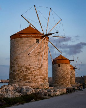Rodos, Yunanistan - 27 Mayıs 2023: Mandraki 'nin yel değirmenleri gün batımında.