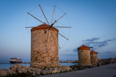 Rodos, Yunanistan - 27 Mayıs 2023: Mandraki 'nin yel değirmenleri gün batımında.