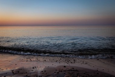 Niechorze, Poland 'da Baltık Denizi üzerinde güzel turuncu gün batımı gökyüzü.. 