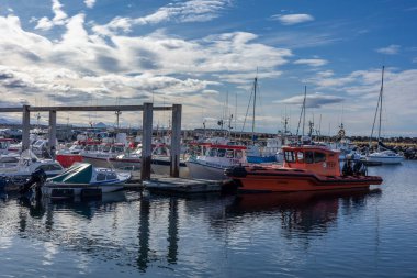 Reykjavik, İzlanda - 25 Eylül 2023: Karsnes limanında demirlemiş renkli balıkçı tekneleri ve yelkenliler, Kopavogur.