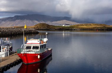 Reykjavik, İzlanda - Ekim 06, 2023: Videy Adası ve Esja Dağı 'nda Videy House (Videyjarstofa) ile Atlantik kıyı manzarası. Kırmızı feribot ön planda.. 