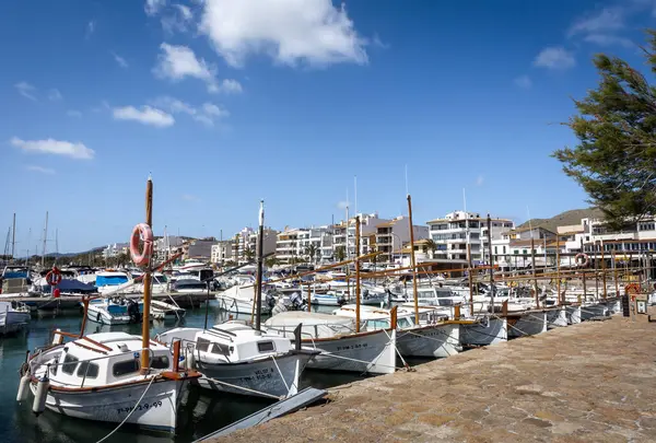 stock image Port de Pollenca, Mallorca, Spain - April 24, 2024: Small fishing boats in the harbour and a seaside promenade. 