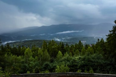 Polonya 'nın Szklarska Poreba kentindeki Zakret Smierci bakış açısıyla Sudetes dağlarının Panoraması. Yeşil orman, yağmurlu gün, vadilerde sis.