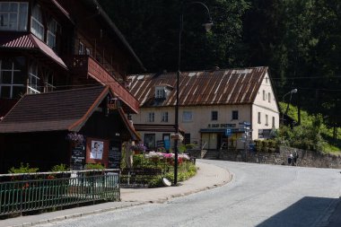 Miedzygorze, Polonya - 19 Haziran 2024: Snieznik Massif dağlarındaki Miedzygorze köyünün ana caddesindeki evler ve dükkanlar. 