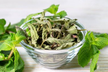 Cam kasede kurutulmuş nane şekeri. Etrafında taze nane tomurcukları var. Yararlar ve sağlık