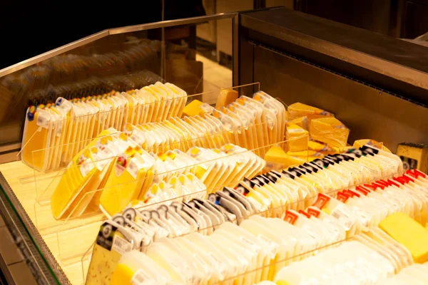 Showcase in a supermarket with packaged cheeses. Trade, shops, business