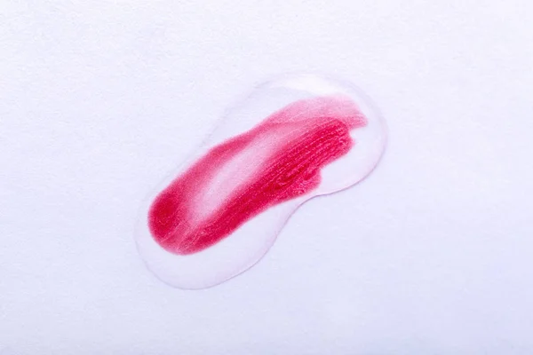 Smear of red nail polish or lip gloss, lipstick under a clear liquid. Check for quality. Cosmetics, makeup, body care