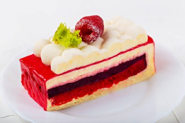 Multilayer cake with raspberry berry on white plate on light background