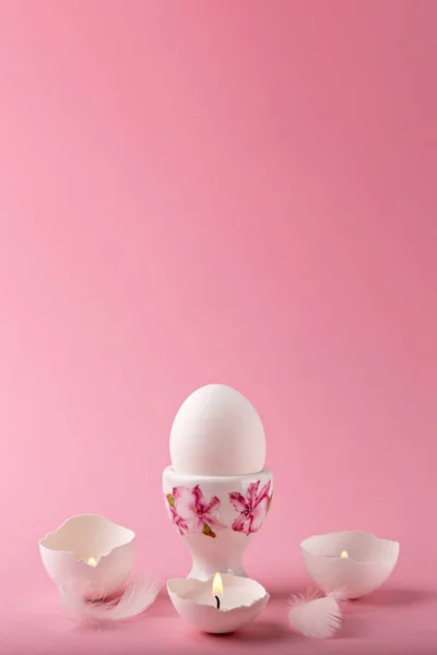 Пасха Белое Куриное Яйцо Стоит Розовом Фоне Свечи Скорлупе Горят — стоковое фото