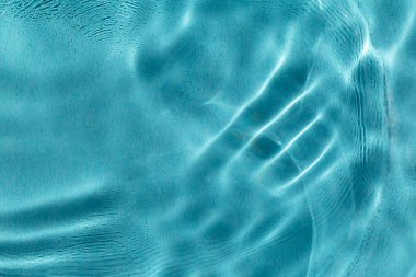 Güneşli havuzda sakin bir su. Huzur ve rahatlama kavramı. Yakın plan, seçici odaklanma, odağını bozma