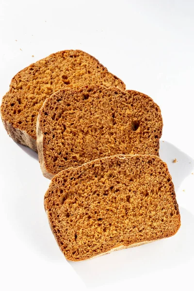 Trzy Kromki Świeżego Ciemnego Chleba Białym Tle Świetle Słonecznym — Zdjęcie stockowe