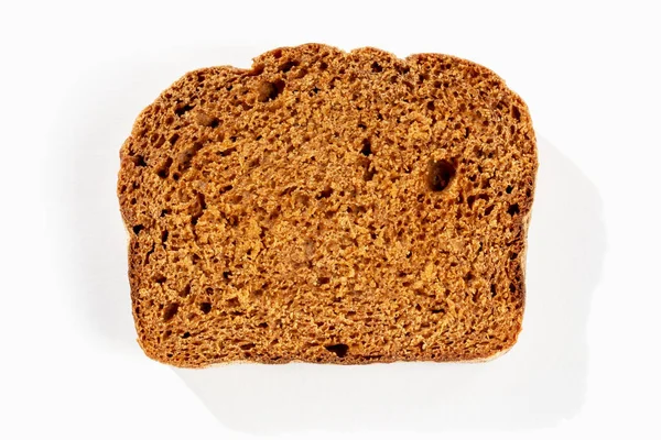 Güneş Işığında Beyaz Zemin Üzerinde Taze Siyah Ekmek Dilimi Yakın — Stok fotoğraf