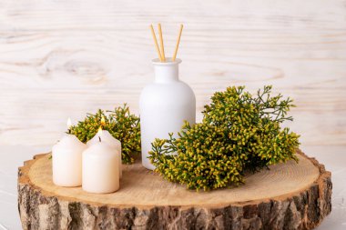 Ahşap çemberde sopaları olan bir sazlık difüzörü. Yanan mumlar ve ardıç dalları sakinlik ve rahatlama ortamı yaratır. Spa, dinlenme, iyileşme