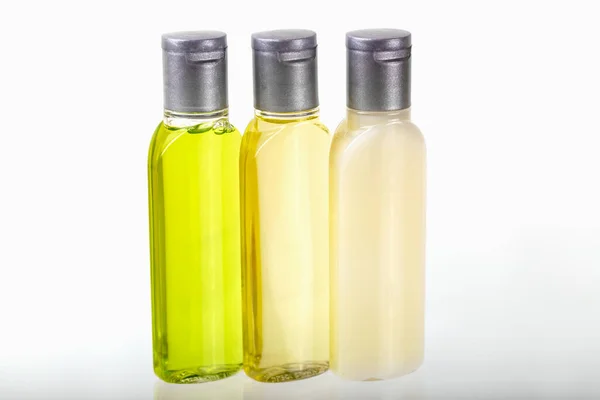 Drie Kleine Flesjes Cosmetica Witte Achtergrond Close Shampoo Douchegel Bodylotion — Stockfoto
