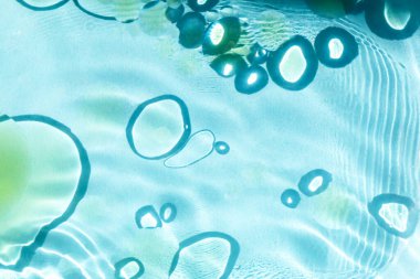 Koyu halkalardaki yağ lekeleri, mavi sudaki güneş ışığı. Kozmetik ve güzellik, bilim ve araştırma. Seçmeli odak, ayrışma