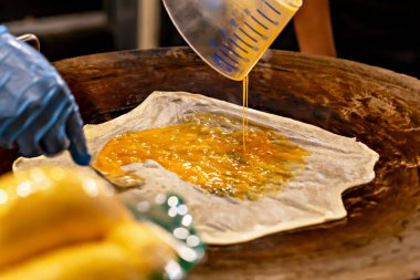 Roti. Çırpılmış yumurtaların yakın plan çekimi hamur üzerine dökülerek ısıtılmış yüzeyde tatlı bir tatlı hazırladı. Canlı renkler lezzetli görünümü arttırır ve sokak yemeklerinin dikkatlice hazırlanmasını sağlar.