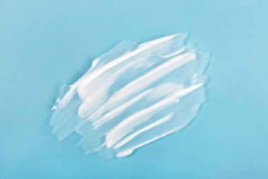 Açık mavi arka planda beyaz krema lekesi. Kozmetik markalaşma, cilt bakımı reklamları ya da yeni ve temiz estetik ile sağlık kampanyaları için mükemmel.