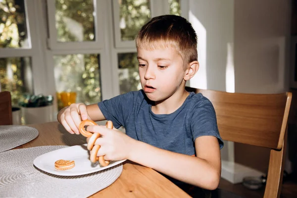 Boy Blue Shirt Eats Bagels Kitchen Grimacing Bagels Cookies Front — Stock Photo, Image