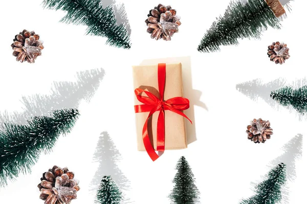 背景与礼物用红色带子 装饰螺丝和松果与阴影白色背景捆绑在一起 圣诞节的图案是平铺的 — 图库照片