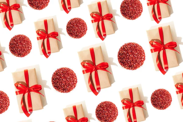 背景和礼物用红色缎带绑着阴影 红色玩具球绑在白色背景上 圣诞节的图案是平铺的 — 图库照片