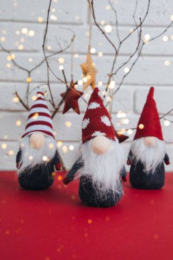 Yeni yıl, Noel geçmişi. Kuru dalları, oyuncak yıldızları, cüceleri olan kırmızı bir masada yeni yıl dekoru. Ön görünüm