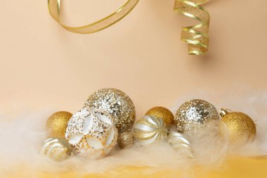 Yeni yıl ve Noel geçmişi. Sarı arka planda altın ve beyaz renkli, melek saçlı Noel topları. Ön görünüm