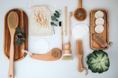 Ahşap çevre dostu cihazlar. Fırçalar, bez ve kulak çubukları, doğal sabun, beyaz arka planda tekstil torbaları. Düz yatıyordu