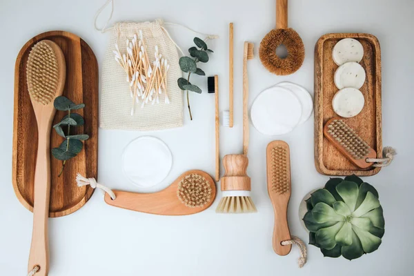 Ahşap çevre dostu cihazlar. Fırçalar, bez ve kulak çubukları, doğal sabun, beyaz arka planda tekstil torbaları. Düz yatıyordu