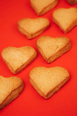 Shortbread cookies in the form of hearts on a red background. Background, Valentines Day. Top view, selective focus