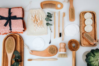 Ahşap çevre dostu cihazlar. Fırçalar, bez ve kulak çubukları, doğal sabun, beyaz arka planda tekstil torbaları. Düz yatıyordu
