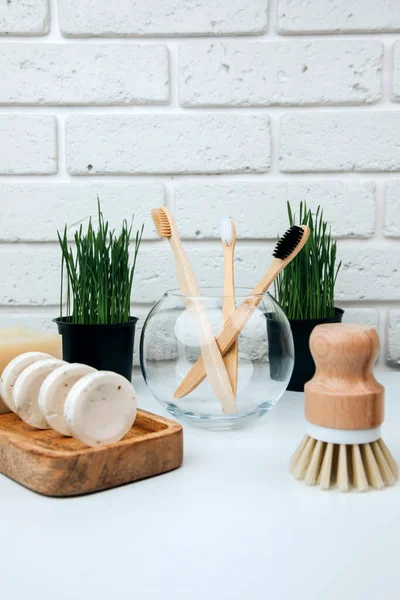 Set of eco friendly products. Washing brush and natural soap on a white marble tray with eucalyptus sprigs. Front view